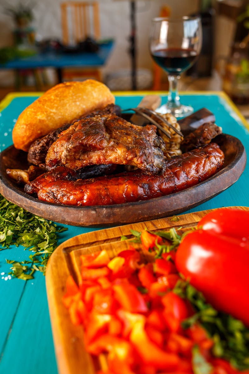 Delicious Argentine grill plate with fresh bread, peppers, and glass of wine.